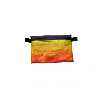 Small fabric pouch with rainbow gradient from yellow to orange, purple top edge and black zipper pulls on the sides