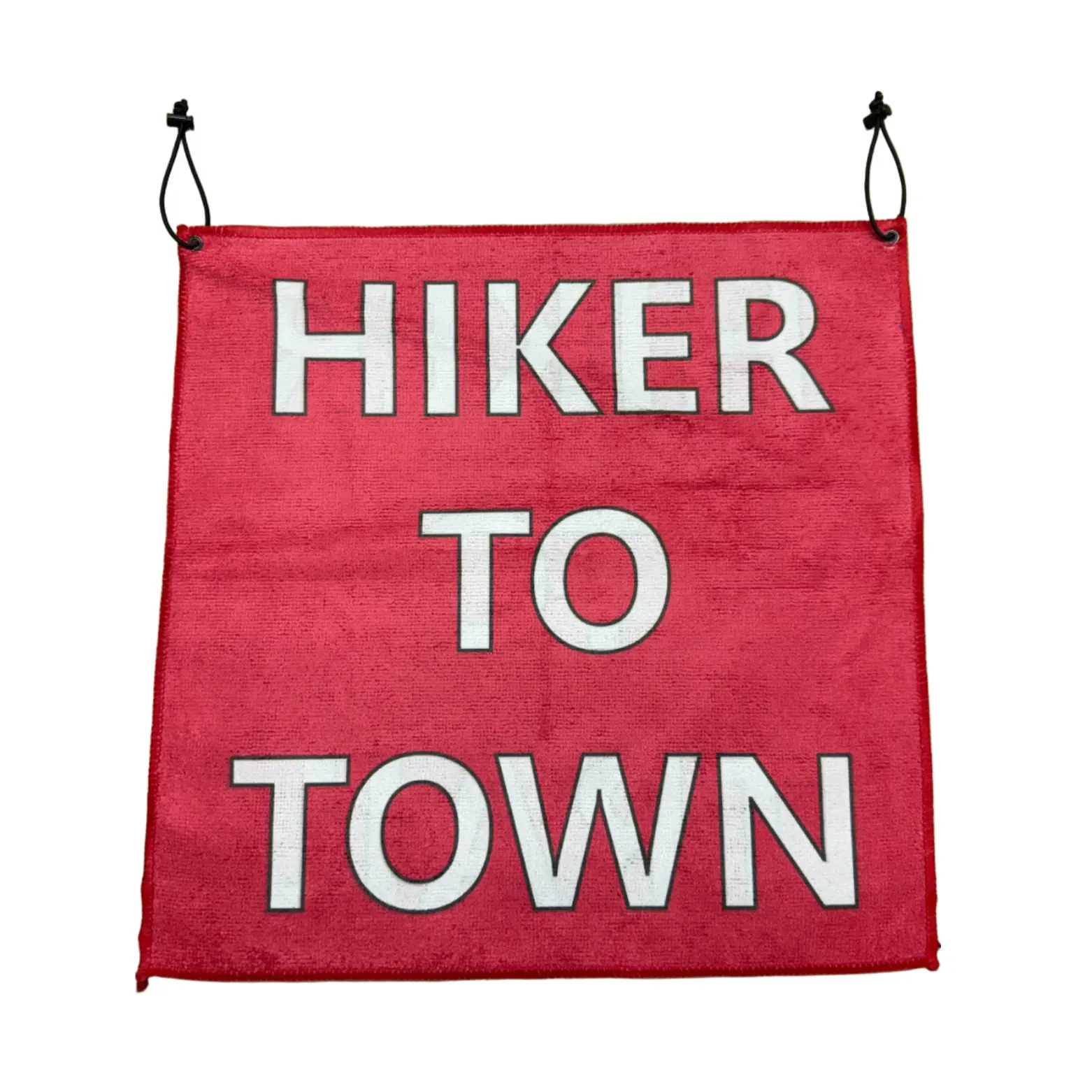 Red fabric banner with bold white letters reading 'HIKER TO TOWN,' hung by two black cords on either side.